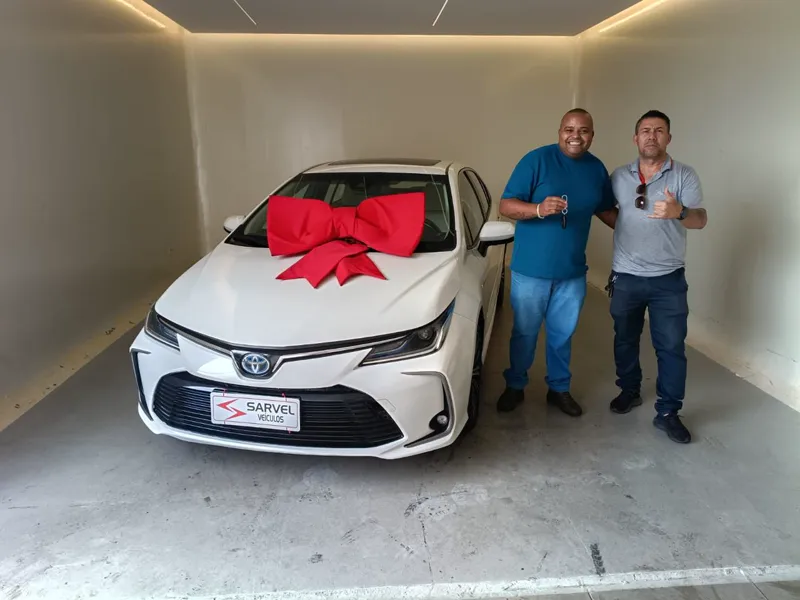 Cliente da Sarvel recebendo o carro, com o laço no capô