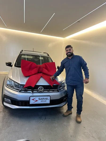Cliente da Sarvel recebendo o carro, com o laço no capô
