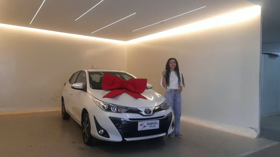 Cliente da Sarvel recebendo o carro, com o laço no capô