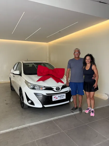 Cliente da Sarvel recebendo o carro, com o laço no capô
