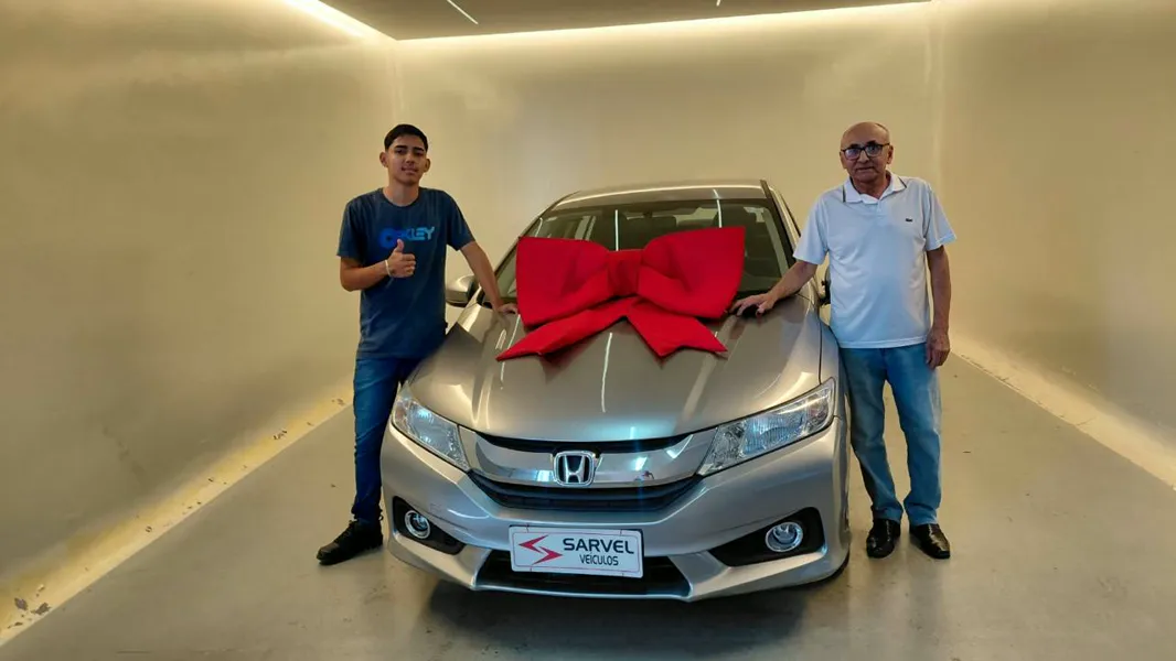 Cliente da Sarvel recebendo o carro, com o laço no capô