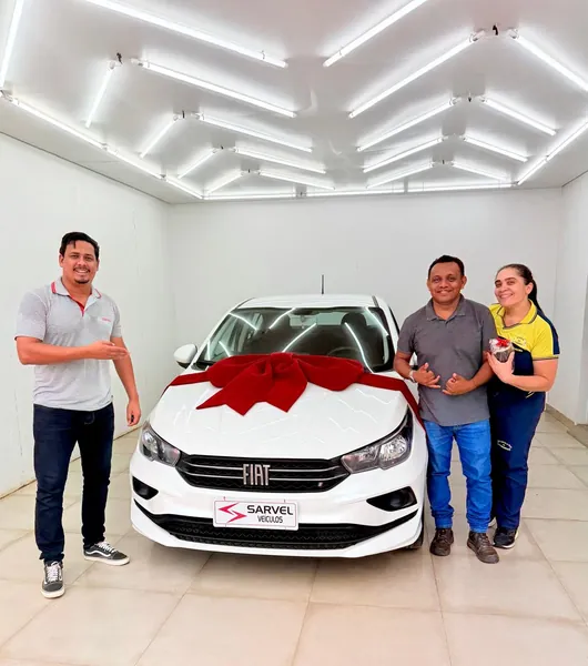 Cliente da Sarvel recebendo o carro, com o laço no capô