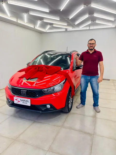 Cliente da Sarvel recebendo o carro, com o laço no capô