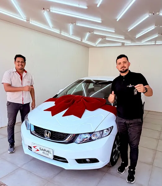 Cliente da Sarvel recebendo o carro, com o laço no capô